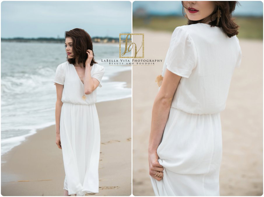 Woman in a flowing white dress walks on a serene beach, gazing into the distance. The scene conveys tranquility and elegance.